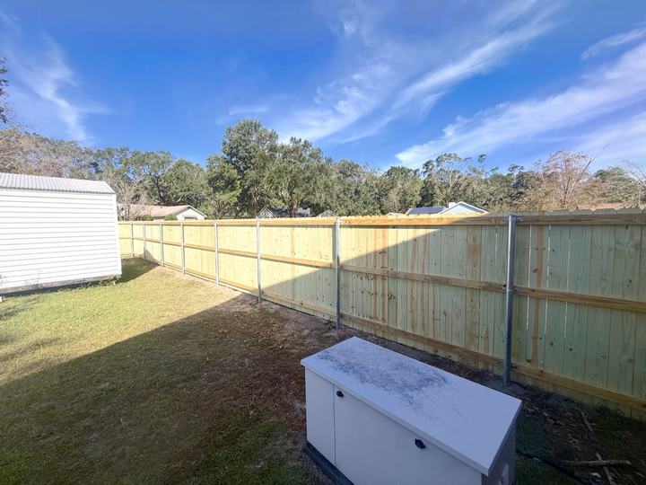 Wood privacy fence with galvanized steel posts along a backyard